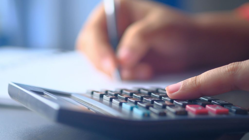 A picture of a person using a calculator representing calculating billboard impressions.