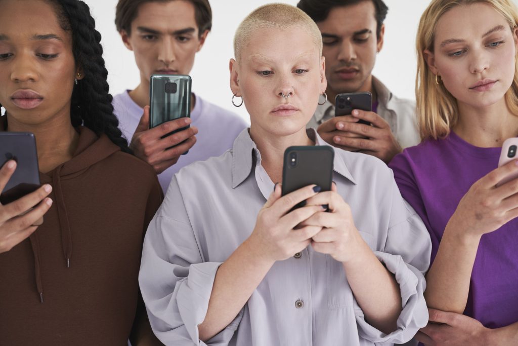 A photo of a diverse group of people staring at their phones.