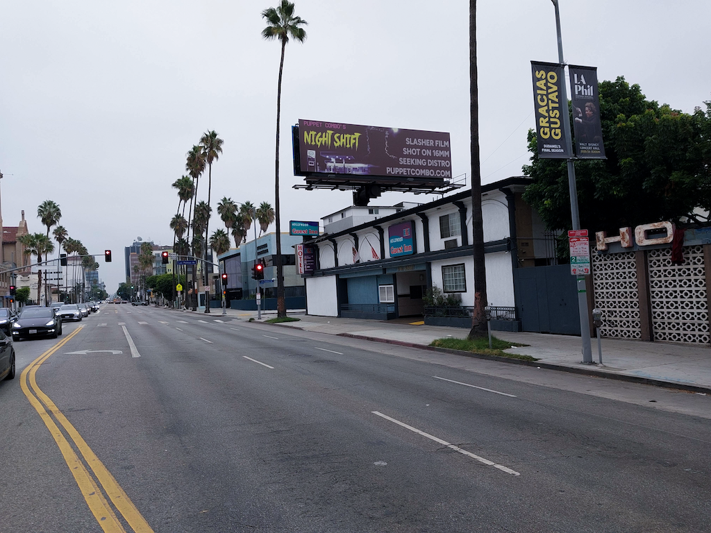 A billboard ad on a busy city street for a film company.