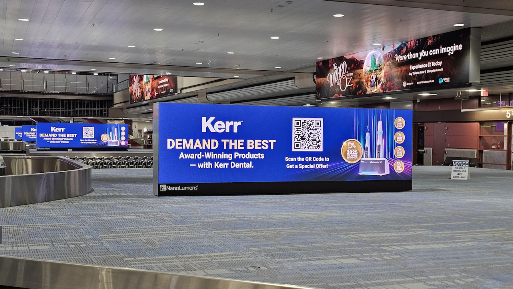 An airport ad for Kerr Dental at the baggage claim with a QR code and and pictures of the dental products with a blue background.