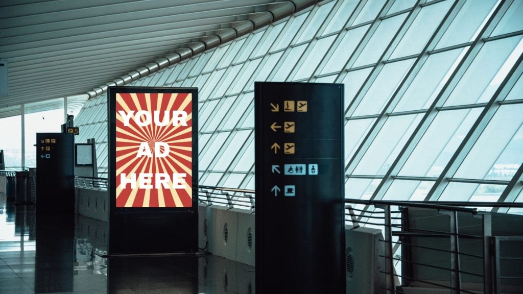 A picture depicting the best ways to advertise in airports with a digital billboard that reads Your Ad Here.