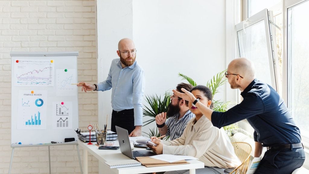 Marketing team reviewing charts and analytics during a strategy meeting, demonstrating collaboration and planning for a successful GTM strategy.